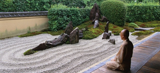 Monk Meditating by Zen Rock Garden